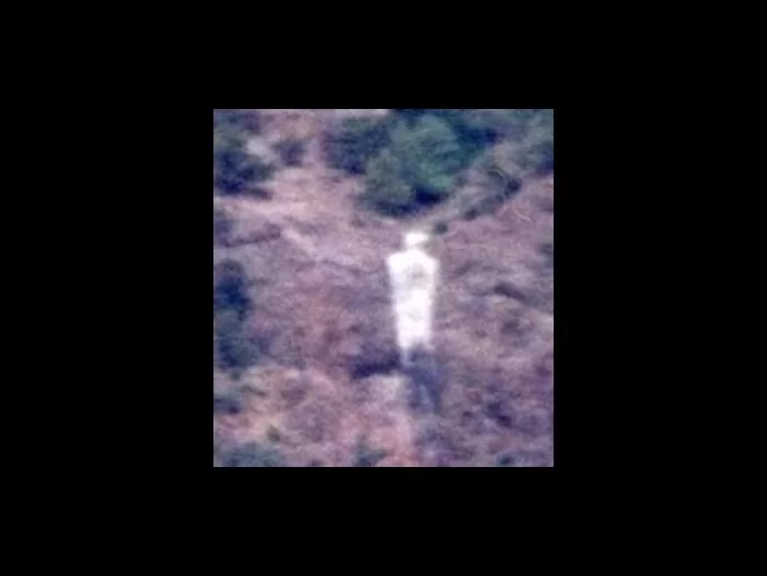 The picture shows a human form, possibly a desert spirit, of someone walking a trail.