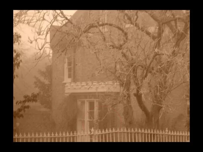 Apparition picture of what may be a little girl in front of an old house. From Shawn G.