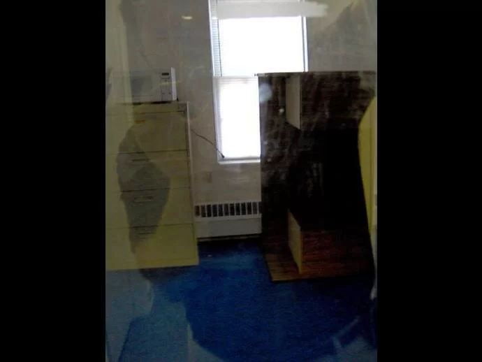 A person reflected in glass appears see-through like an apparition...